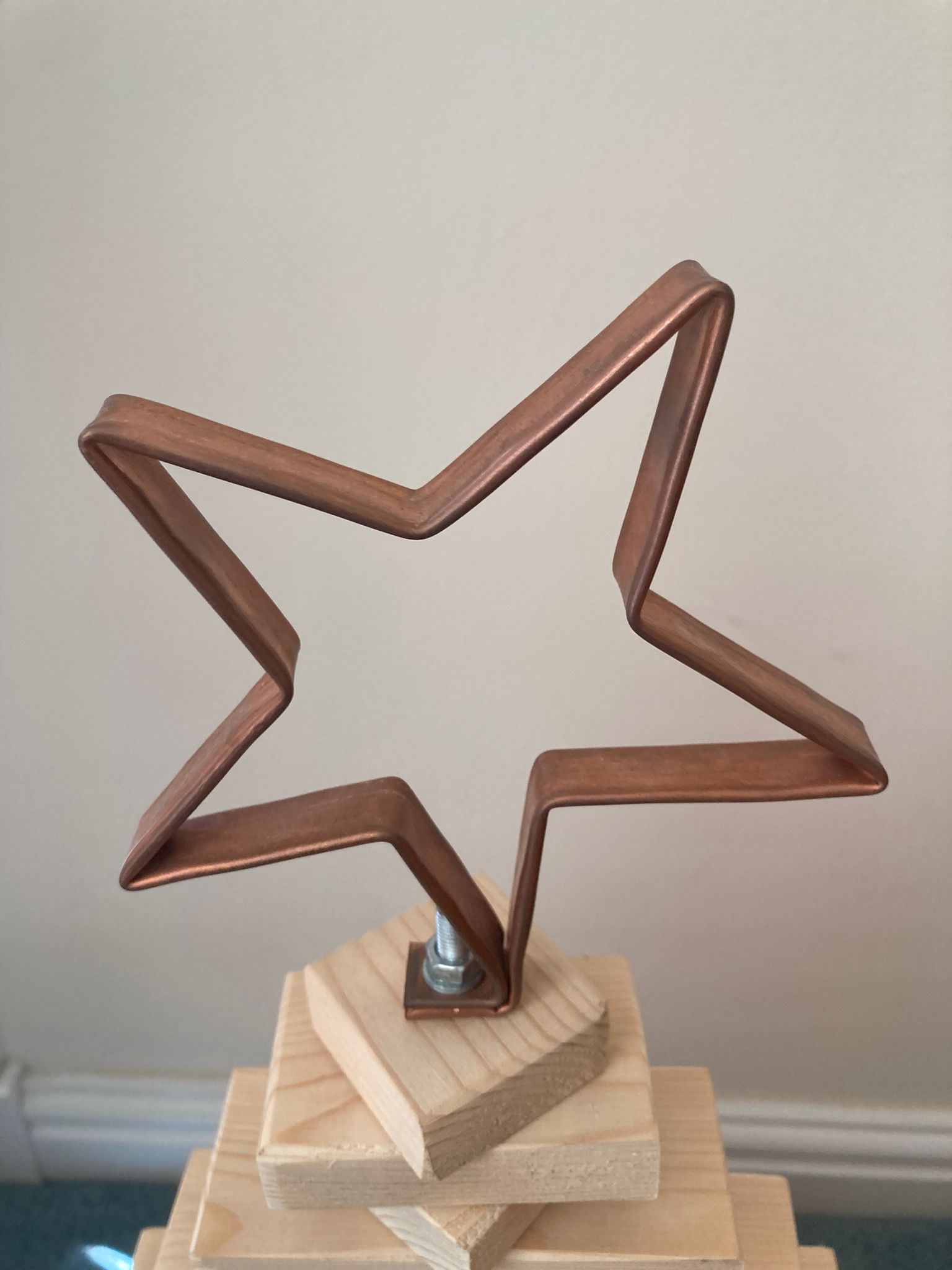 Copper pipe star decoration on wooden base