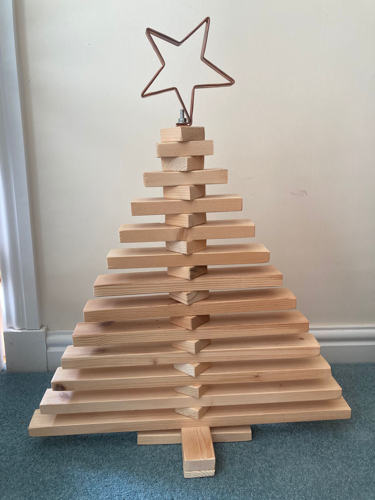 Minimal wooden Christmas tree with copper pipe star